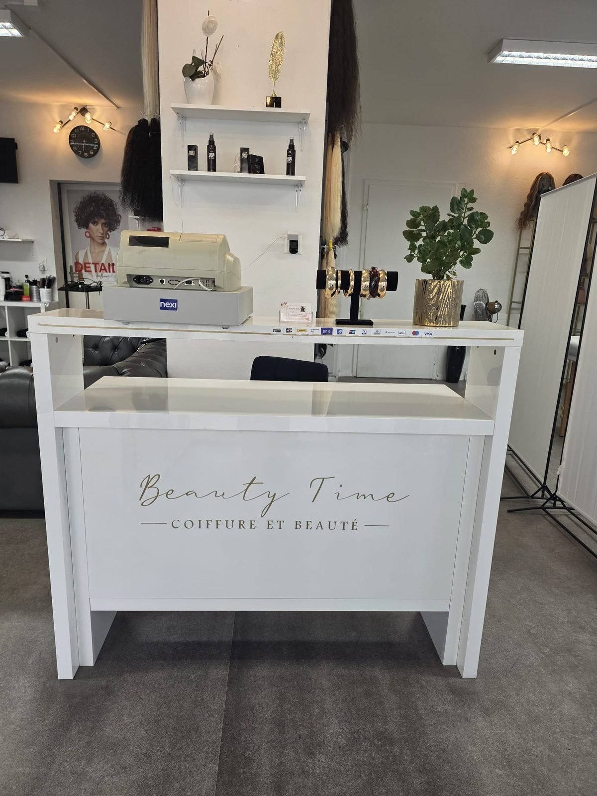 Comptoir d'accueil Beauty Time avec le logo doré et les mèches d'extensions de cheveux
