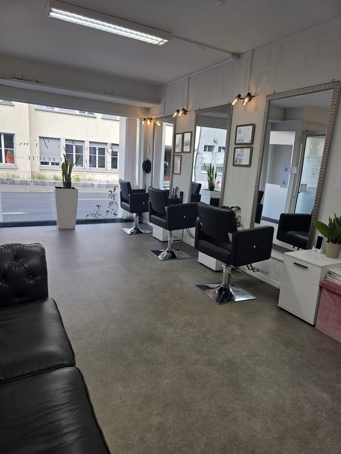 Postes de coiffage du salon Beauty Time à Bienne, fauteuils noirs face aux miroirs