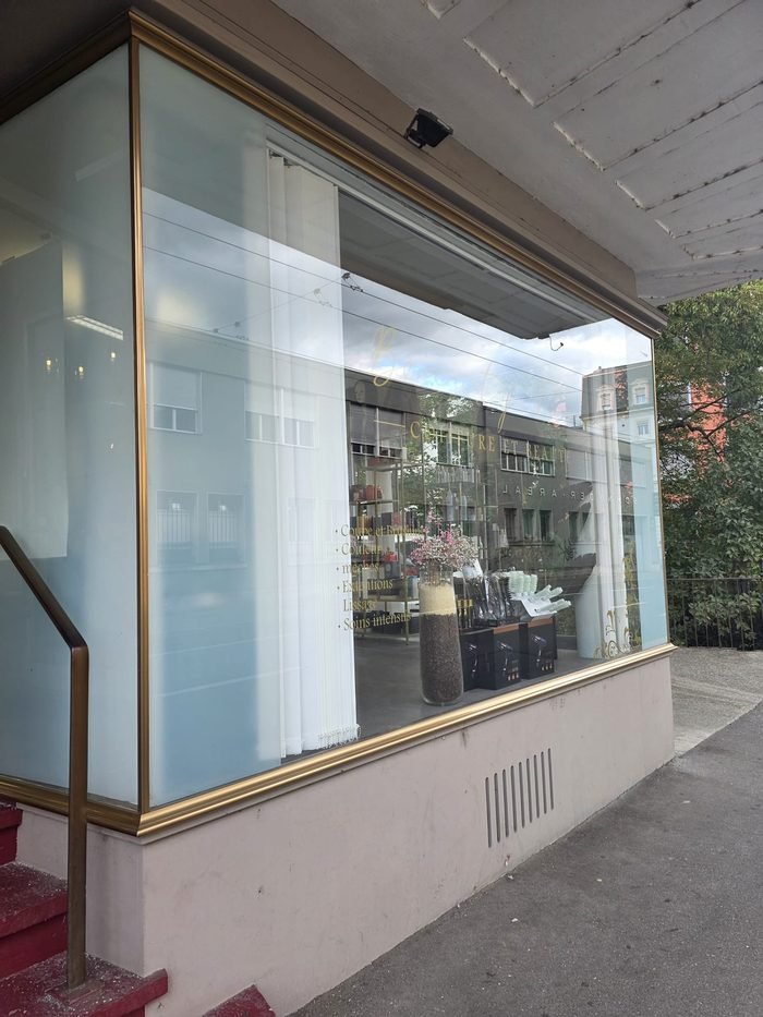 Vitrine listant les prestations : coupe, brushing, couleur, mèches, extensions, lissage, soins