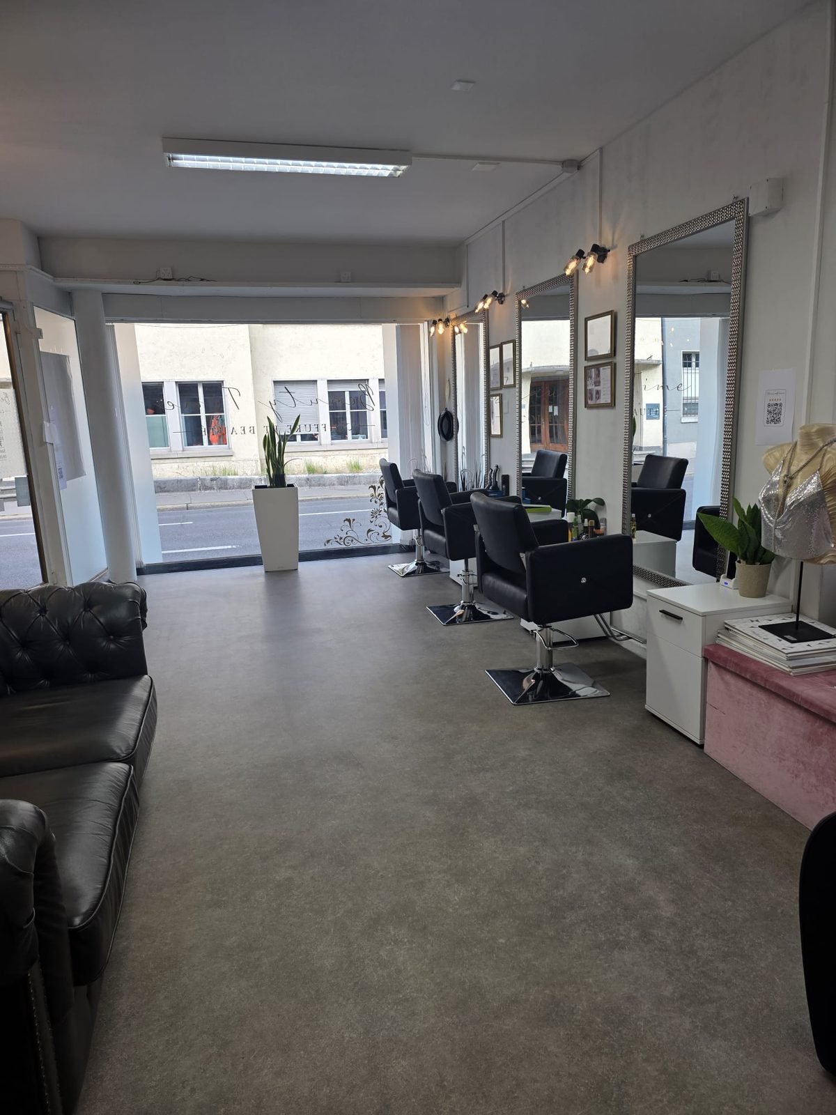 Intérieur du salon de coiffure Beauty Time à Bienne, postes de coiffage et grands miroirs dorés
